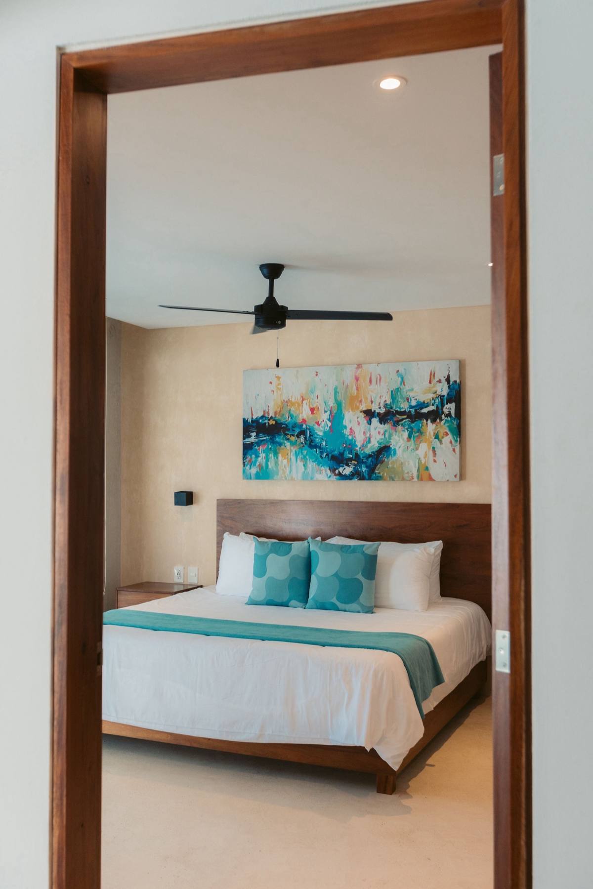 Hotel bedroom interior styled with teal accents and natural light