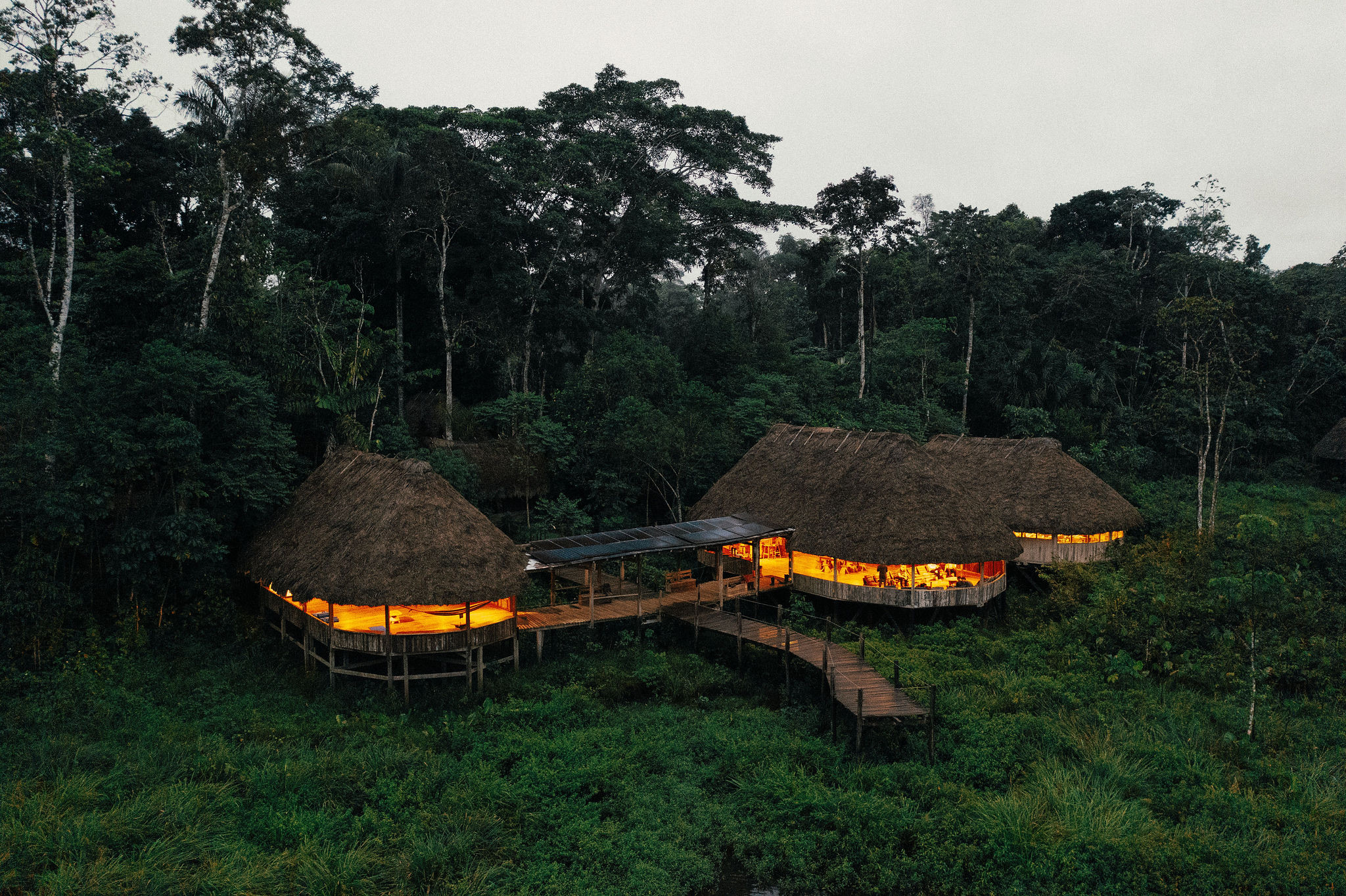 Aerial view of Kapawi Ecolodge illuminated at dusk in the Amazon jungle