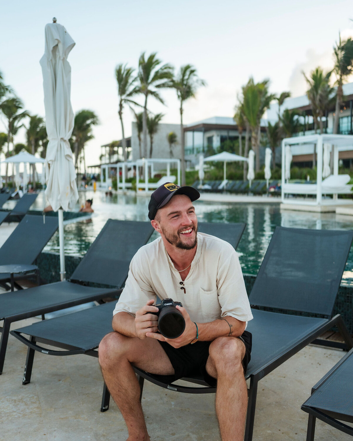 World Wide Stays videographer holding a camera poolside during a hotel production shoot